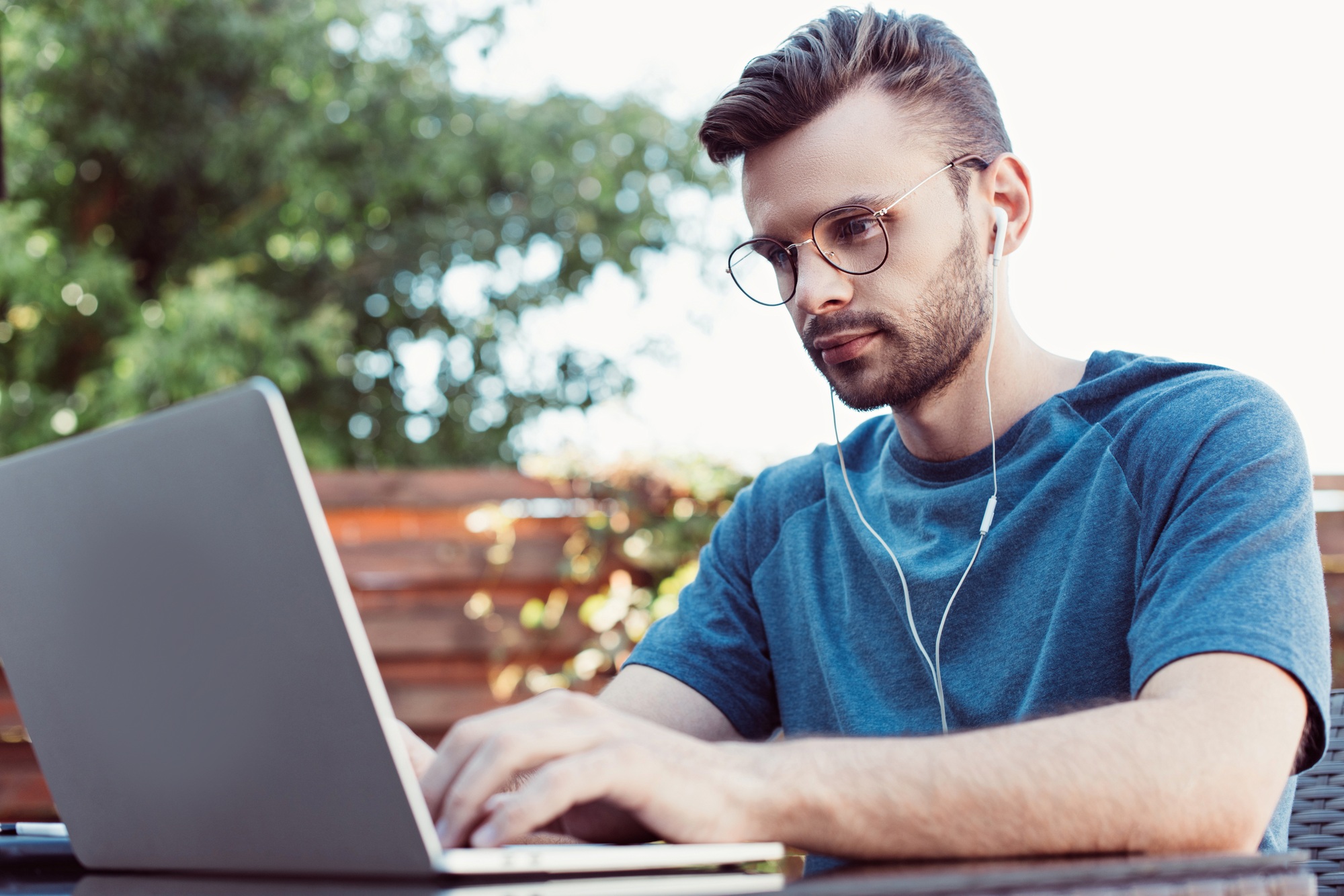 handsome man taking part in webinar at table in park